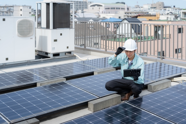 太陽光パネルをメンテナンスしている男性