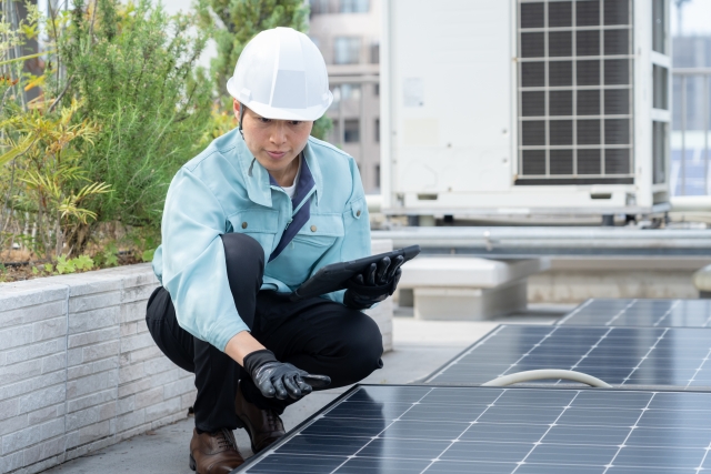 太陽光パネルをチェックしている作業員