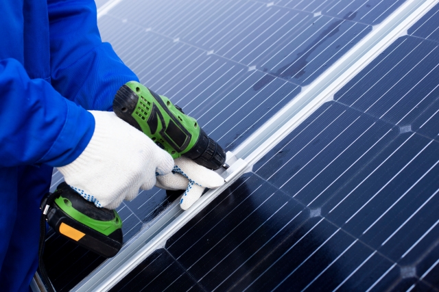 太陽光パネルのメンテナンスをしている男性